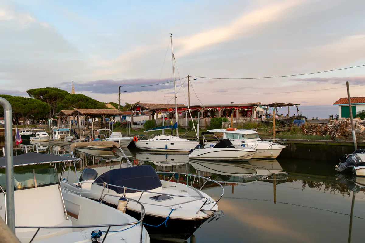 Bateaux amarrés au port d'Andernos-les-Bains devant les cabanes ostréicoles, en fin de journée