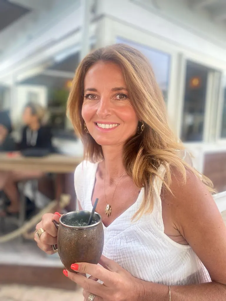 Magali, votre hôte, souriante, une tasse à la main