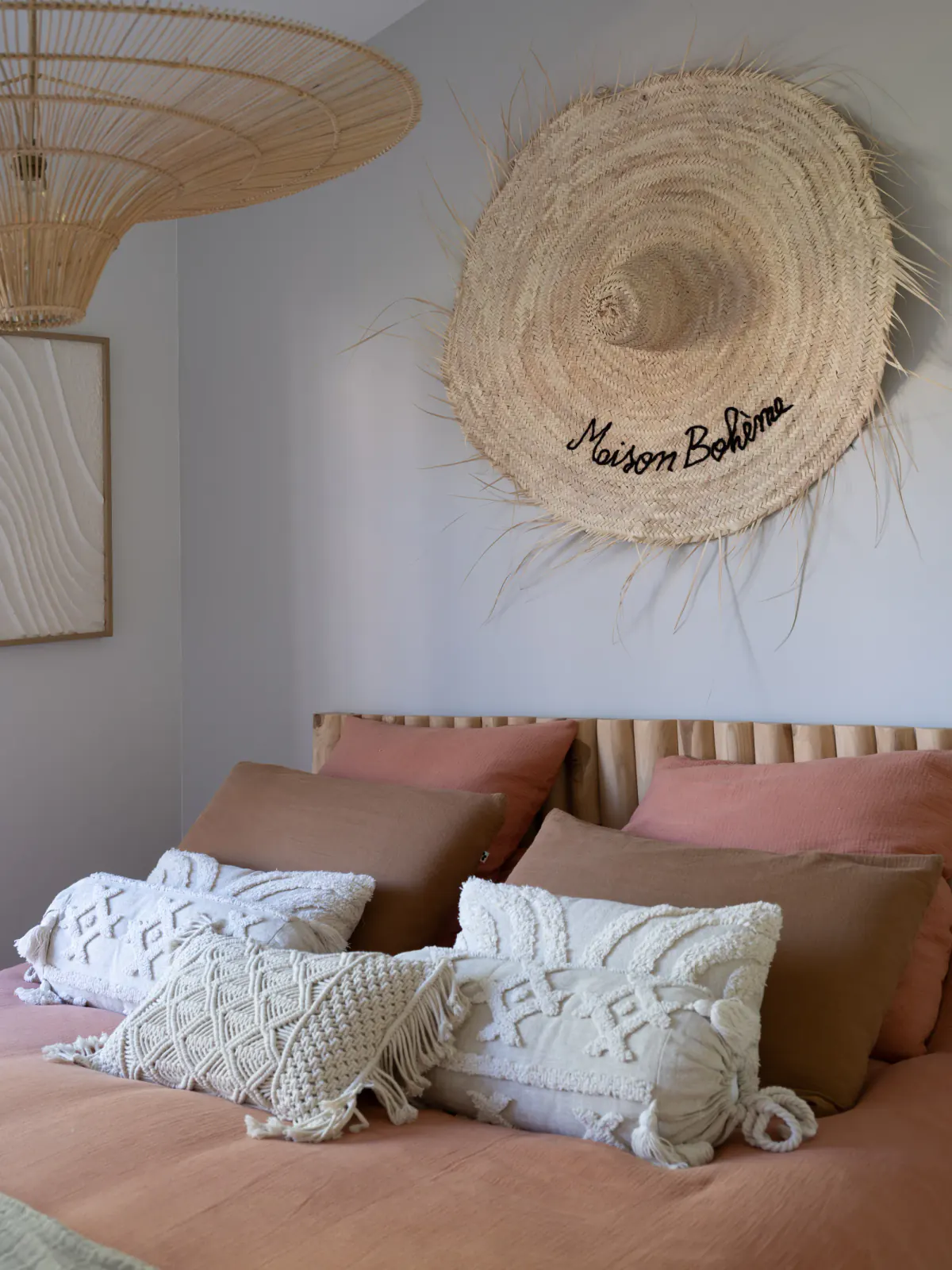 Lit aux coussins en macramé sous un chapeau de paille « Maison Bohème »